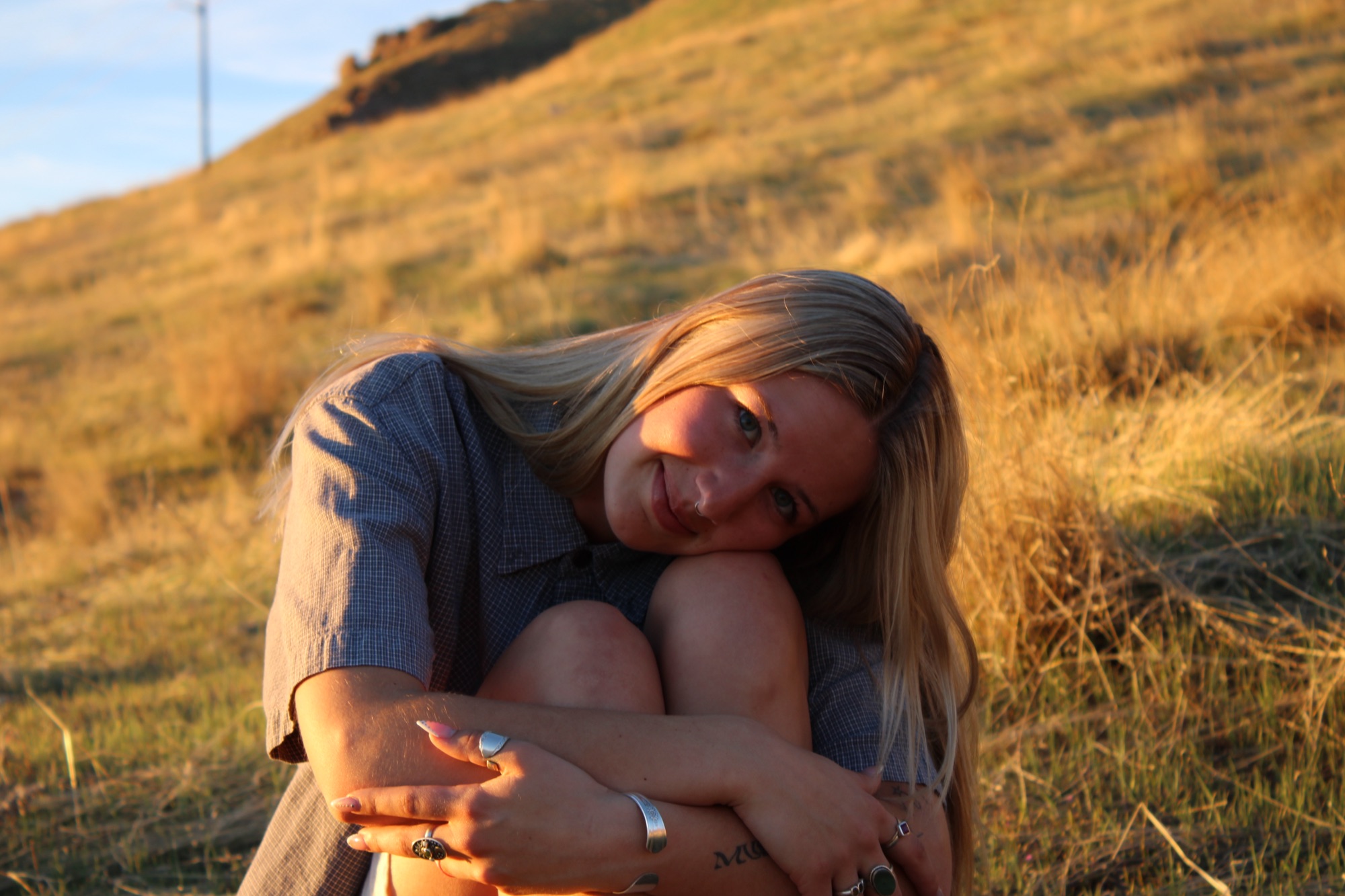 Senior portrait on golden hillside at sunset